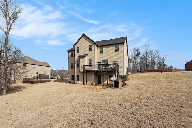 rear view of house featuring a yard and a deck