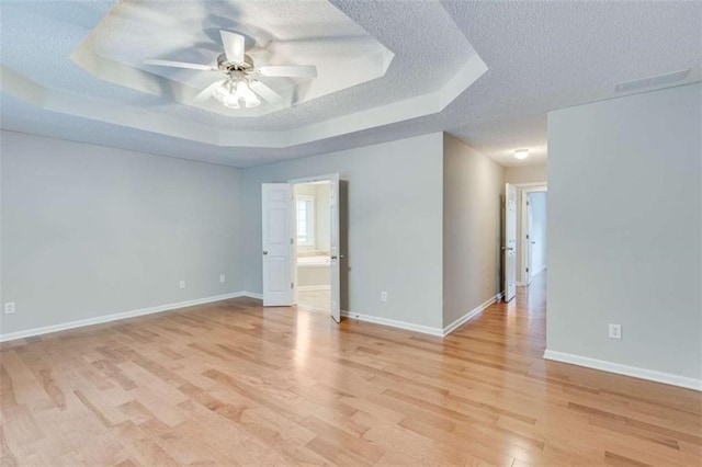 1227 Casper Ln, Winder, GA 30680 - spare room with a textured ceiling, a raised ceiling, light wood finished floors, a ceiling fan, and baseboards
