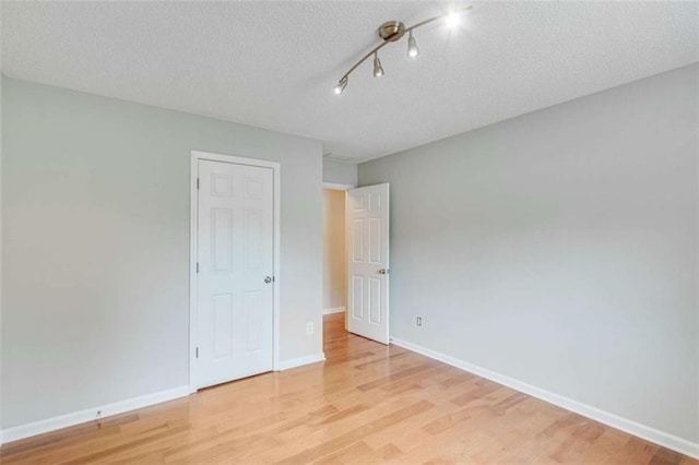 1227 Casper Ln, Winder, GA 30680 - unfurnished bedroom with light wood-type flooring, a textured ceiling, and baseboards