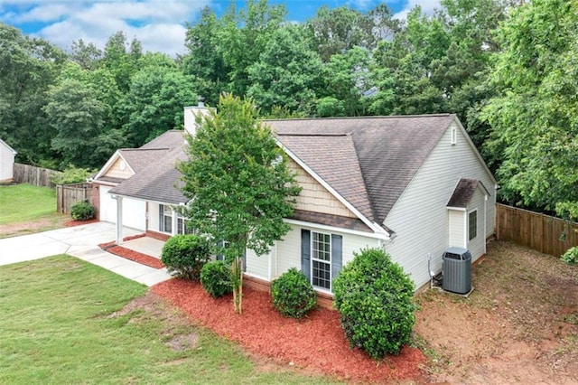 1227 Casper Ln, Winder, GA 30680 - view of front facade with a shingled roof, central air condition unit, concrete driveway, and a chimney