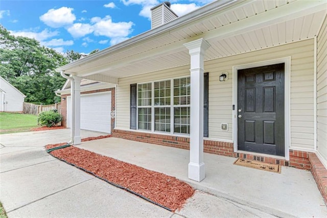 1227 Casper Ln, Winder, GA 30680 - doorway to property with driveway, brick siding, covered porch, and an attached garage