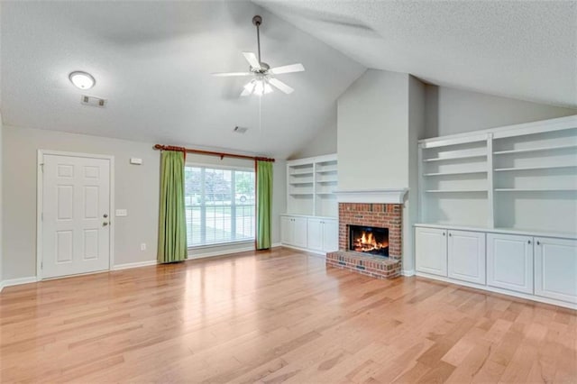 1227 Casper Ln, Winder, GA 30680 - unfurnished living room with a textured ceiling, a ceiling fan, light wood-style flooring, a brick fireplace, and baseboards