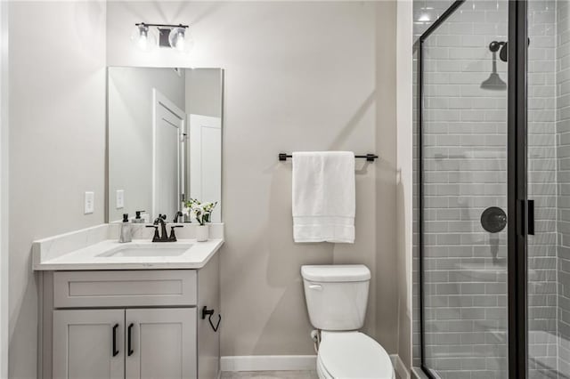 bathroom featuring vanity, toilet, and a shower with door