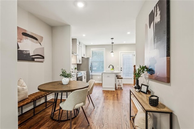 dining room featuring wood-type flooring and sink