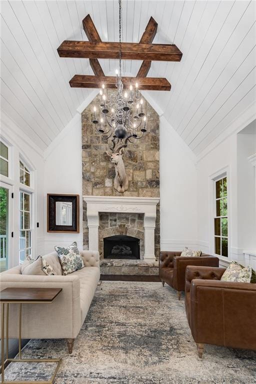 living area featuring wood ceiling, beam ceiling, a fireplace, high vaulted ceiling, and a notable chandelier