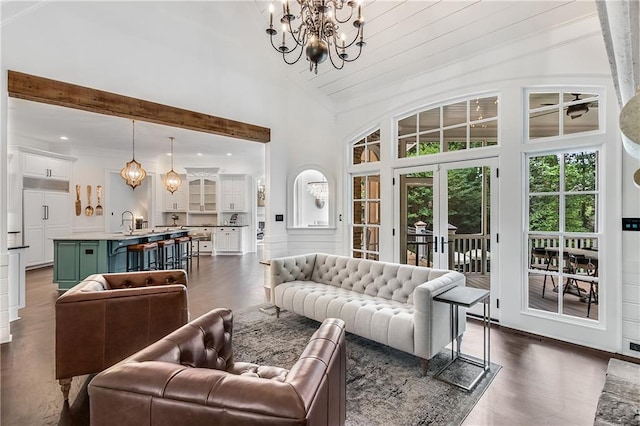 living room featuring a chandelier, french doors, and high vaulted ceiling