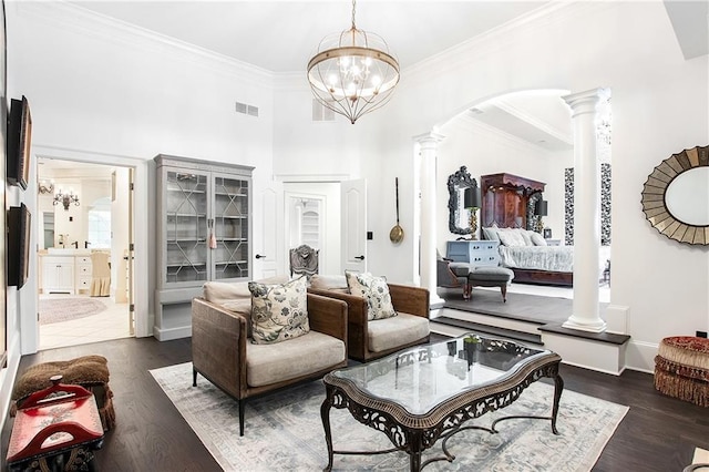 living room with ornate columns, visible vents, arched walkways, and dark wood-type flooring