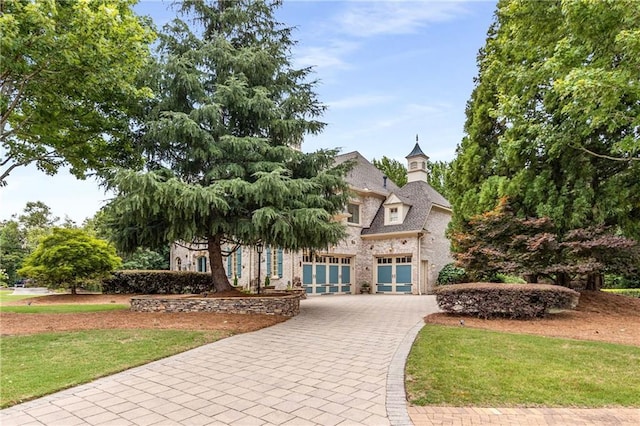 view of front of property featuring a front yard and decorative driveway