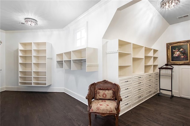 walk in closet with dark wood-style floors, lofted ceiling, and visible vents