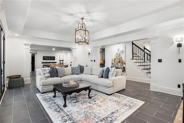 living room featuring crown molding, stairs, and ornate columns