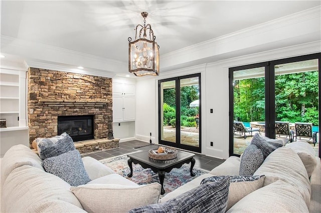 living room with ornamental molding, french doors, and a stone fireplace