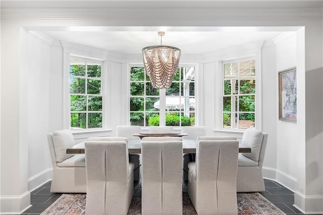 dining area featuring a chandelier, ornamental molding, dark tile patterned floors, and baseboards