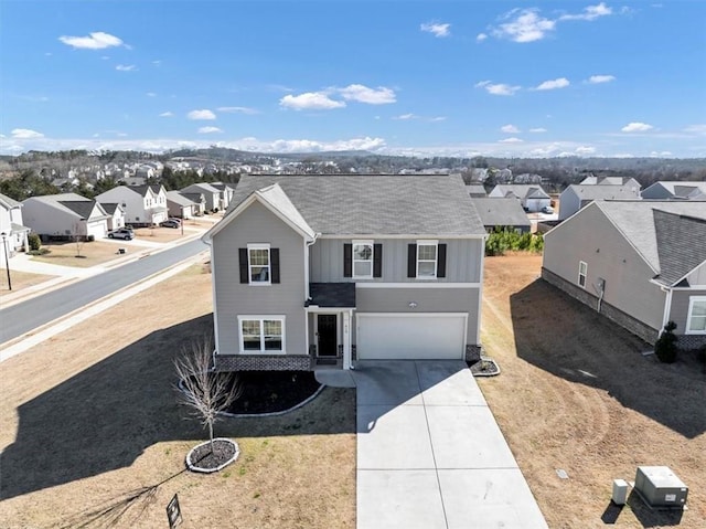 traditional home with a garage, driveway, board and batten siding, and a residential view