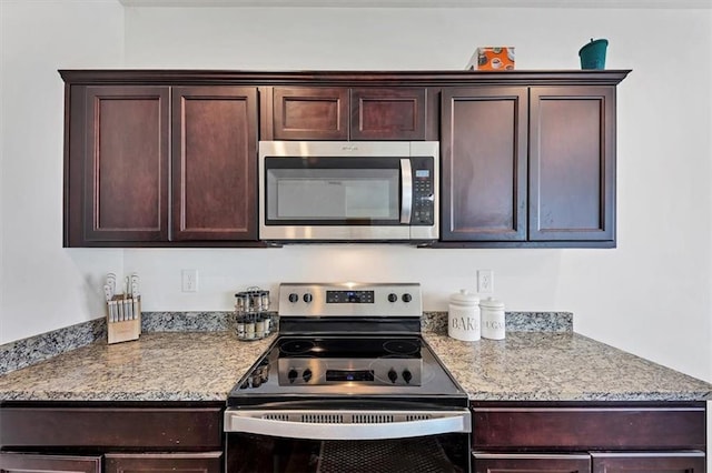 kitchen with dark brown cabinets, appliances with stainless steel finishes, and light stone countertops