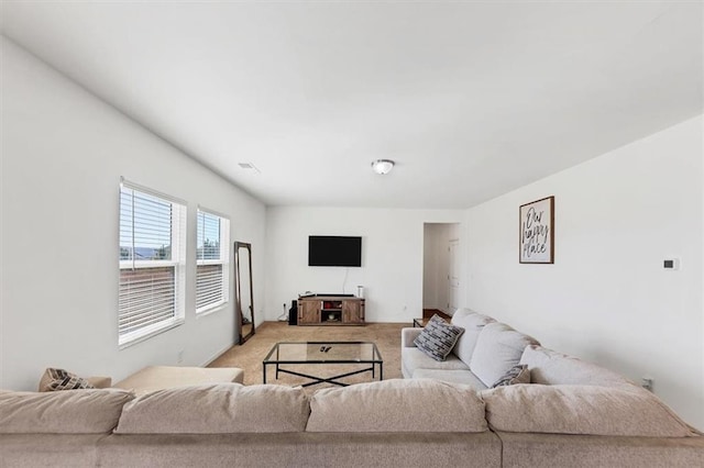 living area featuring visible vents and light colored carpet