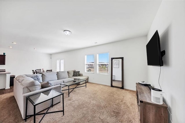 living area featuring light colored carpet and baseboards