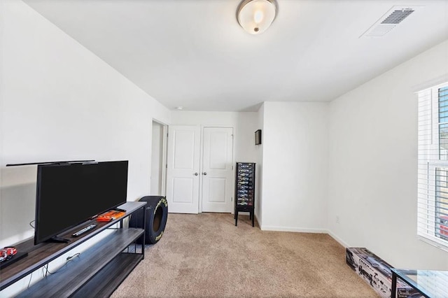 office space featuring carpet floors, plenty of natural light, visible vents, and baseboards