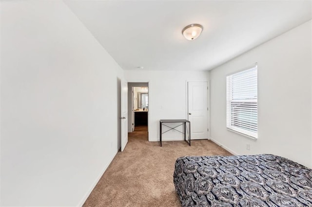 bedroom featuring light carpet and baseboards