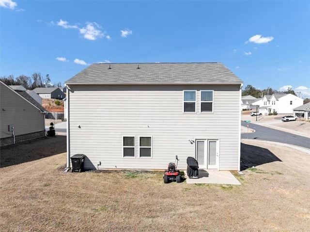 back of property featuring a patio area, a residential view, and a yard