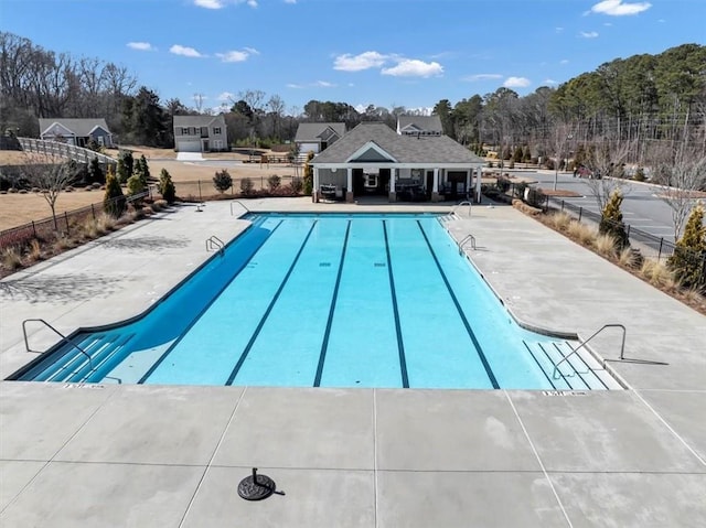 community pool with fence and a patio