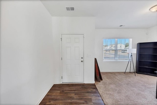 entrance foyer featuring carpet, visible vents, baseboards, and wood finished floors