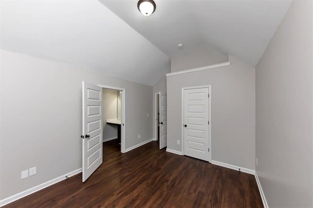 unfurnished bedroom featuring a closet, vaulted ceiling, and dark hardwood / wood-style floors