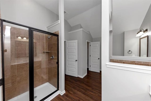 bathroom with lofted ceiling, hardwood / wood-style floors, and walk in shower