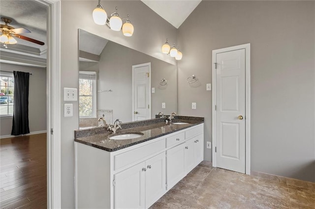 bathroom with ceiling fan, vanity, and lofted ceiling