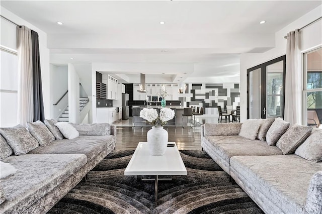 living area with dark wood-style floors, recessed lighting, and stairs