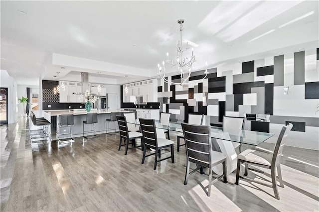 dining area with a notable chandelier and light wood-type flooring