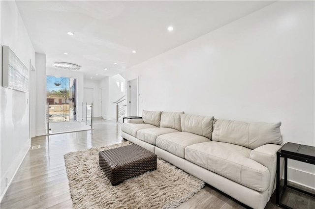 living area featuring recessed lighting, stairway, baseboards, and light wood-style floors