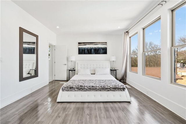 bedroom with recessed lighting, wood finished floors, and baseboards