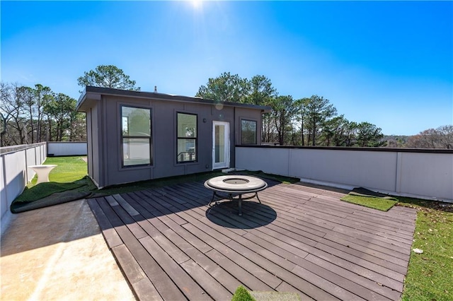 wooden deck with a fire pit and fence