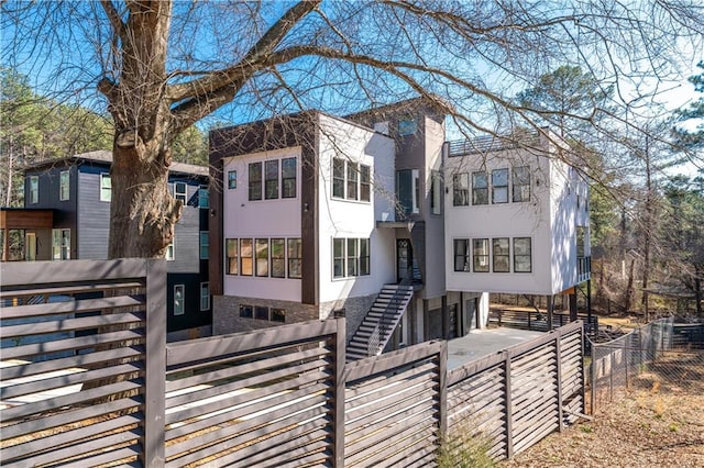 view of front of house featuring stucco siding, a fenced front yard, and driveway