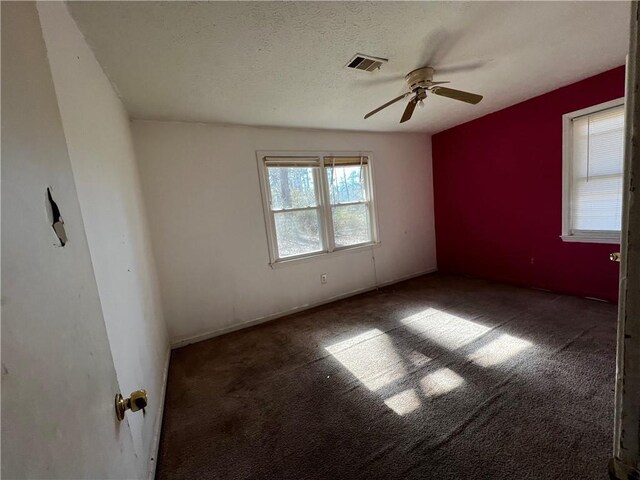 carpeted empty room with ceiling fan and a textured ceiling