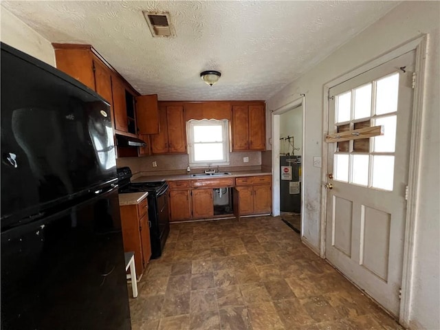 kitchen featuring electric water heater, sink, a textured ceiling, and black appliances