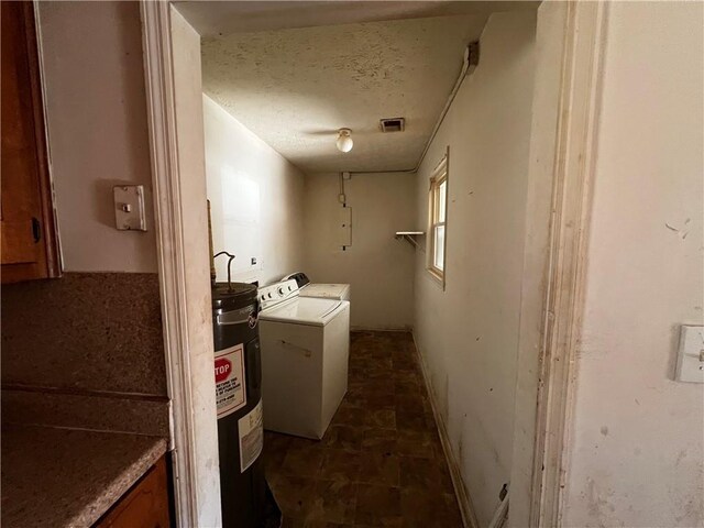 bathroom with washer and clothes dryer, electric water heater, and a textured ceiling