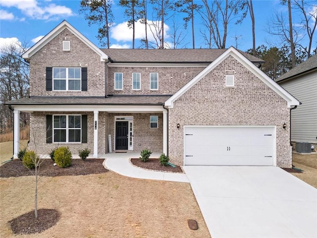 traditional home with brick siding, a porch, concrete driveway, and central AC