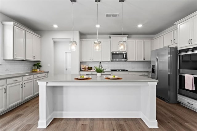 kitchen featuring visible vents, appliances with stainless steel finishes, wood finished floors, and light countertops