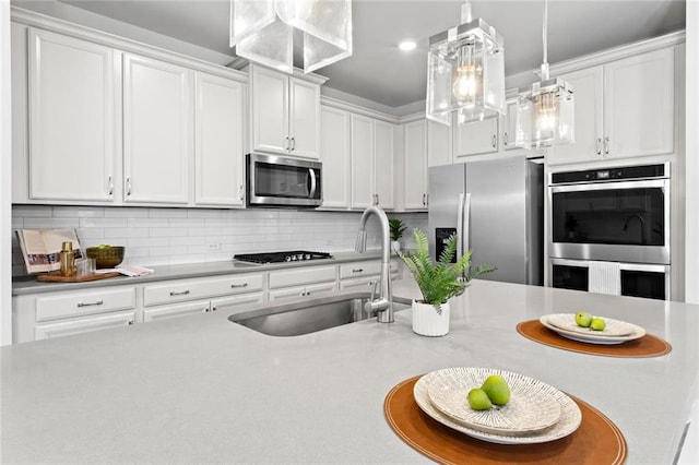 kitchen featuring a sink, light countertops, decorative backsplash, and stainless steel appliances