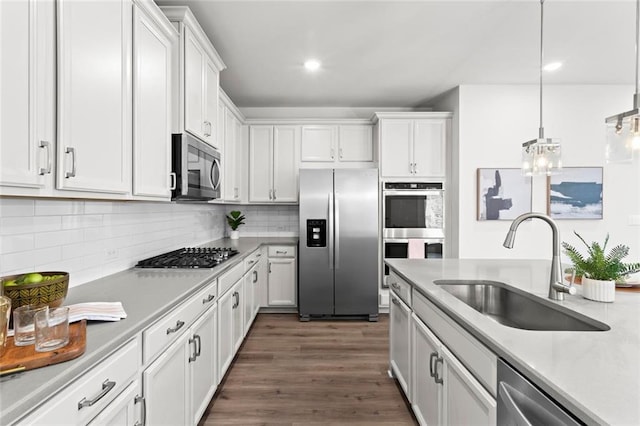 kitchen featuring a sink, light countertops, white cabinets, appliances with stainless steel finishes, and backsplash