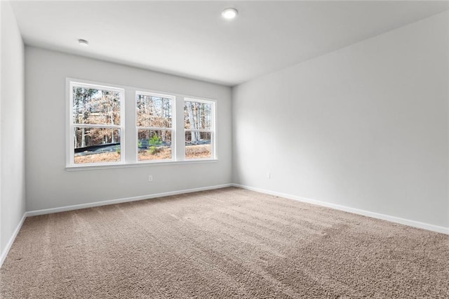 carpeted spare room with baseboards