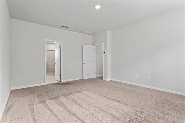 unfurnished bedroom featuring ensuite bathroom, baseboards, visible vents, and carpet floors