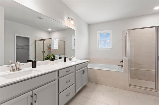 full bath featuring visible vents, a shower stall, a garden tub, and a sink