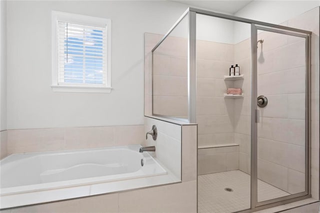 bathroom featuring a stall shower and a bath