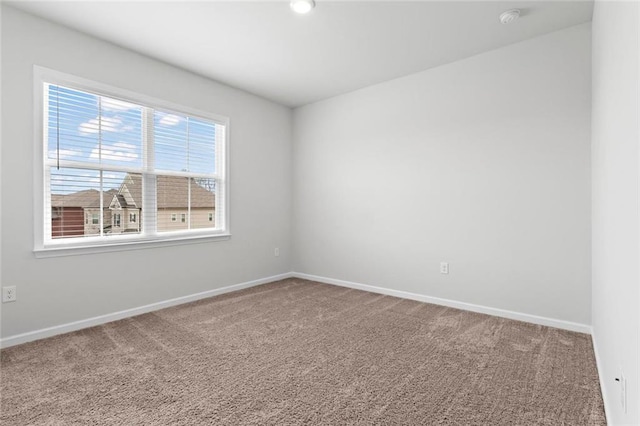 unfurnished room with carpet flooring and baseboards