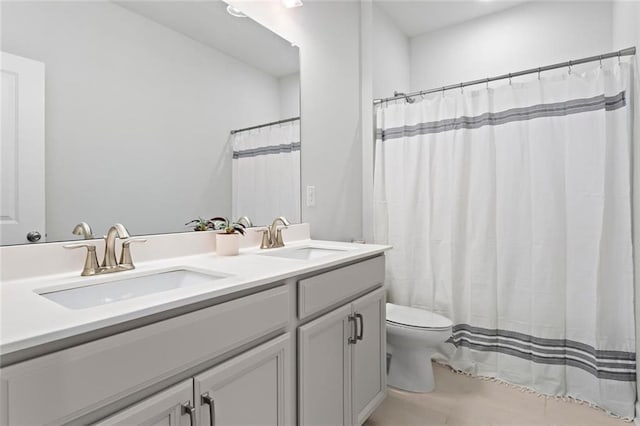 full bathroom with a sink, toilet, double vanity, and tile patterned flooring