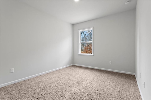 carpeted empty room with baseboards