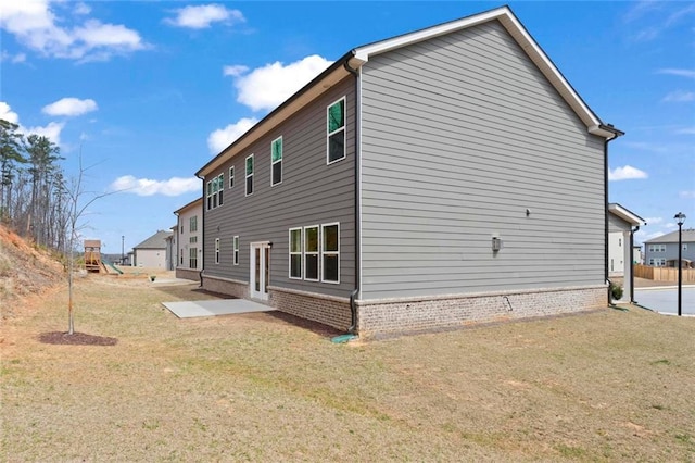 view of home's exterior featuring a patio, a playground, and a lawn