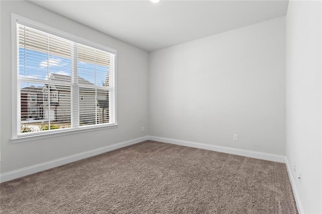 carpeted empty room with baseboards